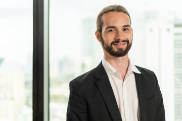 Fototapeta premium Portrait of confident young businessman standing exuding professionalism poise active and dynamic work in modern office, business, leadership, professional men, office life and career success.