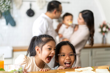 Two curious little girls look at homemade sandwiches on kitchen counter, family cooking time healthy meal preparation, happy children waiting for food, fresh ingredients, healthy eating concept
