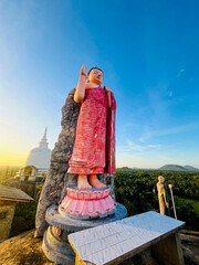 A large Buddha statue in a Buddhist temple at sunset in the province of Sri Lanka