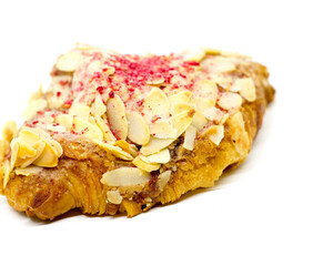 Almond croissants with sliced ​​almonds and dried raspberries sprinkled on top on an isolated white background