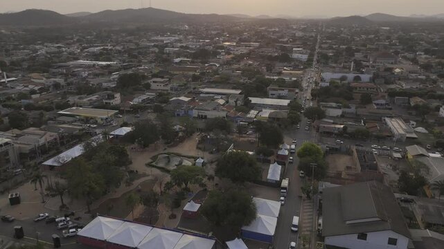 Drone flies backwards from sunset over Pra&ccedil;a da Liberdade in Bonito, Mato Grosso do Sul, Brazil