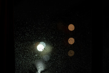 textura de vidrio con gotas de lluvia de noche y bokeh de fondo