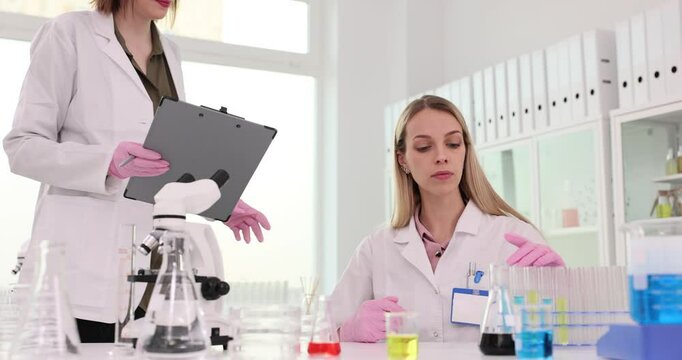 Laboratory assistant scientist chemist examines test tubes with liquids in laboratory
