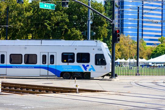 Side view of a VTA light rail vehicle turning to Woz Way in downtown San Jose - San Jose, California, USA - September 15, 2024