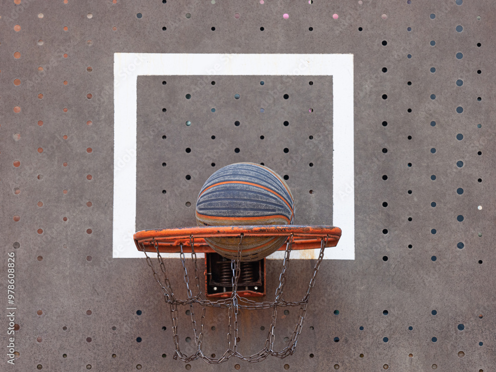 Wall mural striped ball flying into basketball hoop, front view