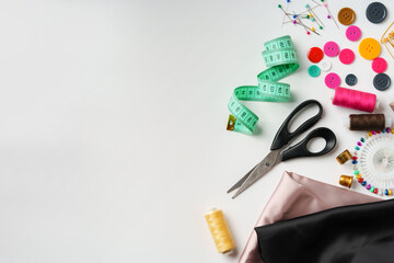 Crafting essentials for sewing projects displayed on a table with fabric, threads, and tools