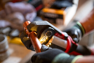 Plumber using press tool to attach fitting to copper water pipe