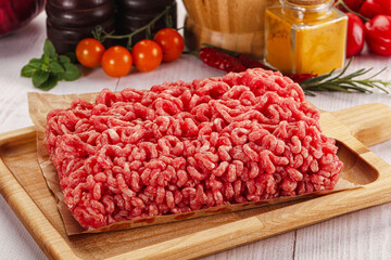 Raw minced beef meat over board