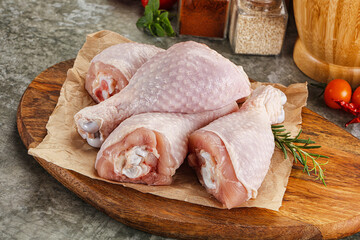 Raw uncooked chicken drumsticks over board