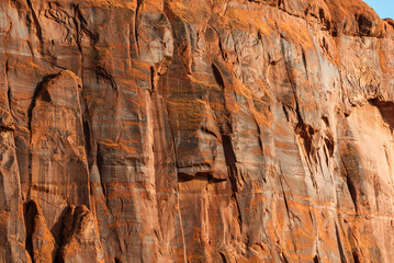 Eroded red sandstone rock face with striations in Monument Valley.