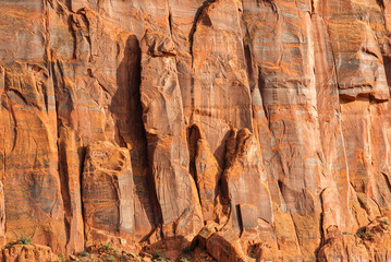 Layered sandstone cliffs with warm hues in Monument Valley.