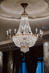 Elegant crystal chandelier glowing in a luxurious room with lighting.