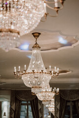 Elegant crystal chandelier glowing in a luxurious room with lighting.