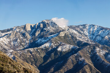 Snow-capped mountains rise under a clear blue sky in the Sierra Nevada