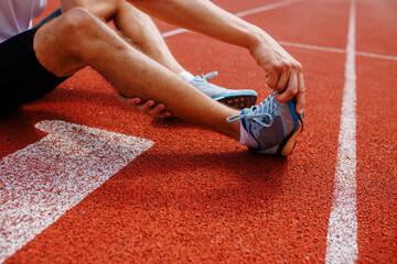 Athlete stretching on running track