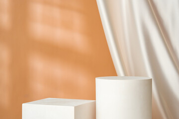 Minimalist decor featuring a white cylinder and draped fabric in a warm-toned interior with soft lighting