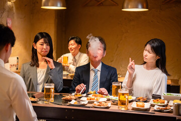 居酒屋でタバコを吸うビジネスマン