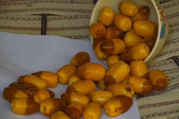 Dates yellow fruit in dish cup on wood paper