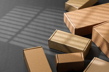 Various sizes of brown cardboard boxes arranged on a black surface with soft lighting effects...