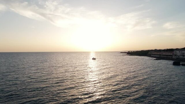 Drone shot panning into a sailboat during sunset on the Tyrrhenian Sea (Lazio, Italy).