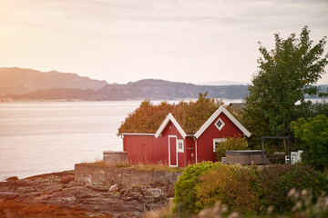 Red house by lake with mountains in background
