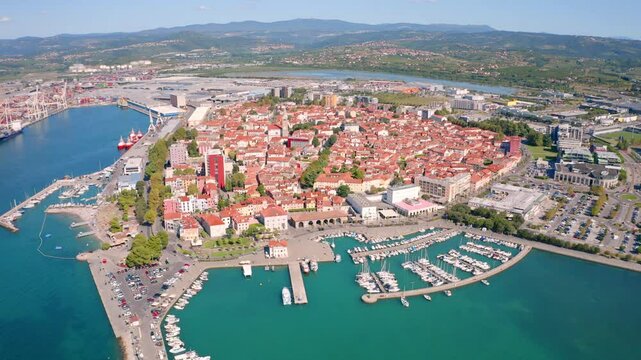 4k drone flight moving to the side and back footage (Ultra High Definition) of Koper port. Aerial morning scene of Adriatic coastline, Slovenia, Europe. Colorful Mediterranean seascape.