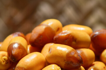 Dates fruit in a bowl on wooden background
