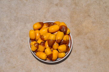 yellow Dates fruit  in a bowl with texture background