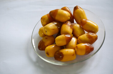 close up of yellow Dates fruit  in a bowl with texture background
