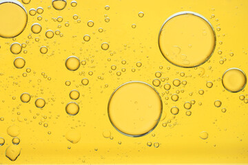 Sample of cosmetic oil on golden background, macro view