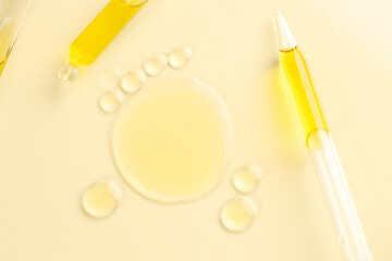 Cosmetic oil and pipettes on dark beige background, flat lay