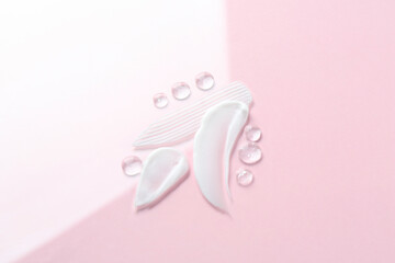 Smears of different cosmetic products on color background, top view