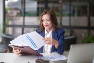 Asian businesswomen reading marketing business paper and checking finance graph to thinking about planning of new business while analyze investment and market stock of new startup in outside office