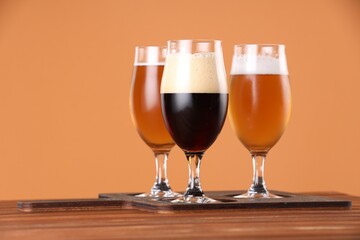Glasses with different types of beer on wooden table