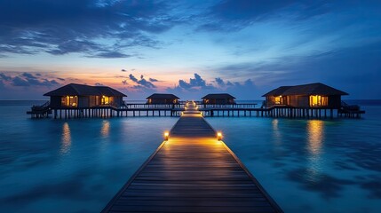 Fototapeta premium Wooden boardwalks leading to overwater bungalows on a serene Maldivian lagoon at dusk.