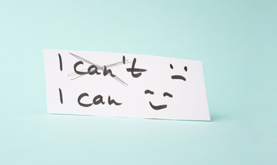 The word can not is standing on a paper, having a goal, postive thinking, be an optimist, do it, self confident, happy and sad face