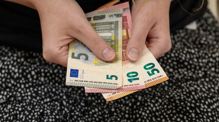 Kobieta trzyma w dłoniach banknoty euro