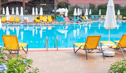 View of Swimming Pool with Sun Loungers at Tropical Resort