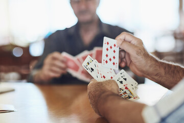 Card, game and people hands in retirement home with senior care, playing and fun on table....