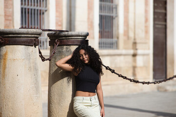 beautiful young latin woman with black and dark eyes and long curly hair with a sad expression...