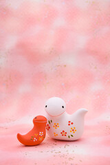 ピンク柄の背景に紅白の蛇の置き物　巳年　年賀素材　