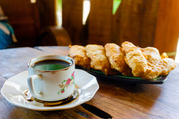 Fried banana on with black coffee on the table. Fried banana is one of the most delicious desserts in the world