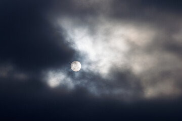 厚い雲から透けて見える太陽