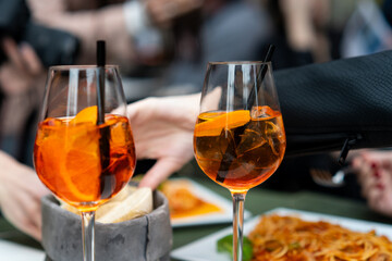 Drinking aperol spritz cocktails at brunch table