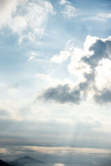 Majestic Mountain Landscape Covered in Mist with Sun Rays Breaking Through Clouds