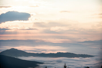 Majestic Mountain Landscape Covered in Mist with Sun Rays Breaking Through Clouds
