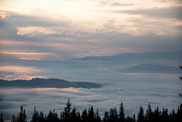 Majestic Mountain Landscape Covered in Mist with Sun Rays Breaking Through Clouds
