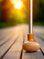 Close-up of a golf putter on a wooden surface, glowing sunlight in the background, capturing the essence of a perfect game.