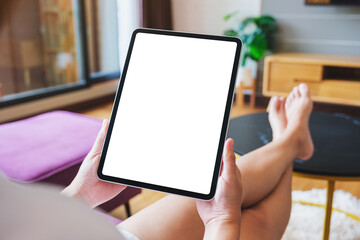 Mockup image of a woman holding digital tablet with blank desktop screen at home