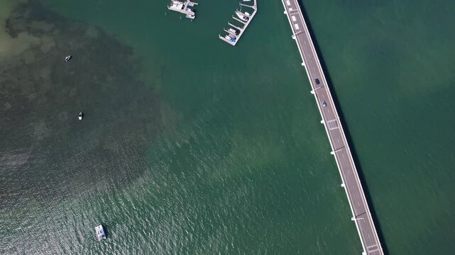 Vehicles Driving On Ephraim Island Bridge Across Waters In Paradise Point, Queensland, Australia. aerial topdown shot